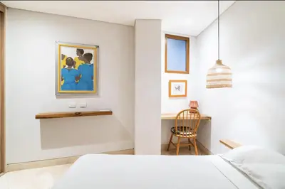 a white bedroom with a bed and a chair at Cozy New Apartment in the Old City in Cartagena de Indias