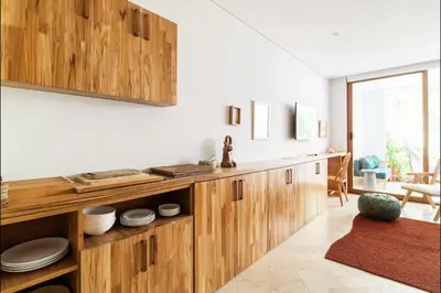 a kitchen with wooden cabinets and a table at Cozy New Apartment in the Old City in Cartagena de Indias