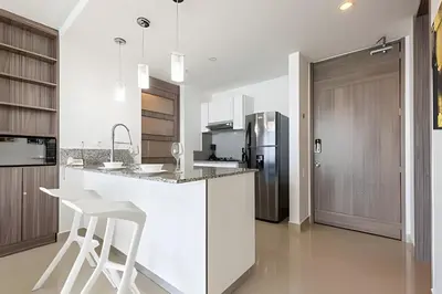a white kitchen with a counter and a refrigerator at Exclusive Sea View “Morros City” 30th Fl in Cartagena de Indias