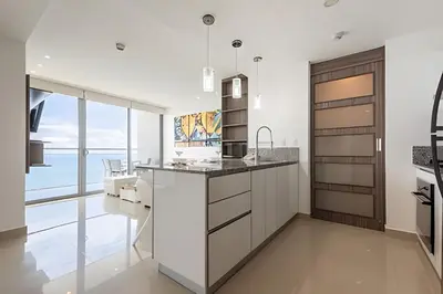 a kitchen with white cabinets and a view of the ocean at Exclusive Sea View “Morros City” 30th Fl in Cartagena de Indias