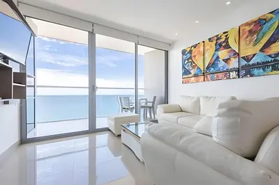 a living room with a white couch and a view of the ocean at Exclusive Sea View “Morros City” 30th Fl in Cartagena de Indias