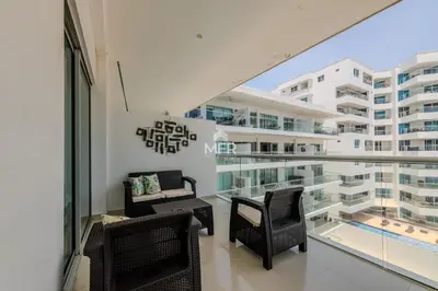 a balcony with chairs and tables and a large building at Morros Epic - La Boquilla, Seaview & 2Bdr in Cartagena de Indias