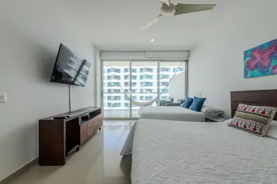 a bedroom with two beds and a flat screen tv at Morros Epic - La Boquilla, Seaview & 2Bdr in Cartagena de Indias