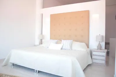 a white bedroom with a large bed with white sheets and pillows at HERMOSOS APARTAMENTOS EN La CIUDAD VIEJA in Cartagena de Indias