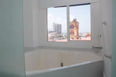 a white bathroom with a window and a bath tub at HERMOSOS APARTAMENTOS EN La CIUDAD VIEJA in Cartagena de Indias