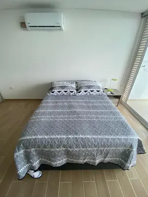 a bedroom with a bed with a gray comforter at Apartamento LOFT INFINITY BLUE in Santa Marta