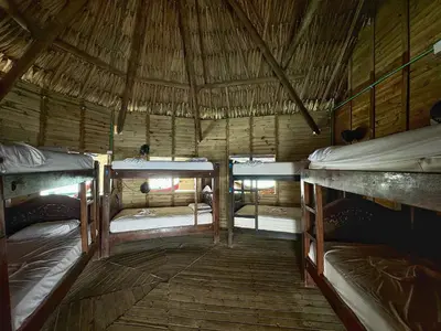 a room with two bunk beds in a straw hut at Casa en el agua in Tintipan Island