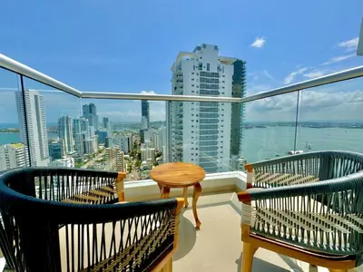 a balcony with two chairs and a table and a view of the city at apto navy 6 tripulantes in Cartagena de Indias