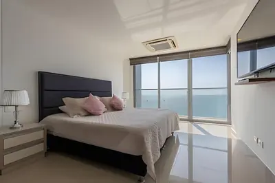 a bedroom with a bed with two pink pillows at Sea View and Historic Center “Morros City” 2BR in Cartagena de Indias