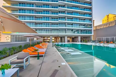 a swimming pool with lounge chairs and a building at Sea View and Historic Center “Morros City” 2BR in Cartagena de Indias