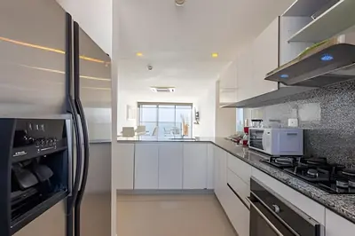 a kitchen with white cabinets and a black refrigerator at Sea View and Historic Center “Morros City” 2BR in Cartagena de Indias