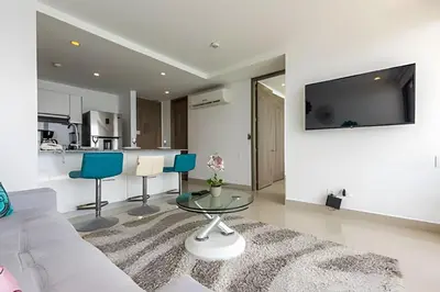 a living room with a couch and a glass table at Vista al Mar y Centro Histórico “Morros City” 26fl in Cartagena de Indias