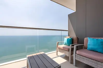 a balcony with two chairs and a table at Vista al Mar y Centro Histórico “Morros City” 26fl in Cartagena de Indias