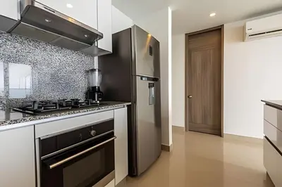 a kitchen with a stove and a refrigerator at Vista al Mar y Centro Histórico “Morros City” 26fl in Cartagena de Indias