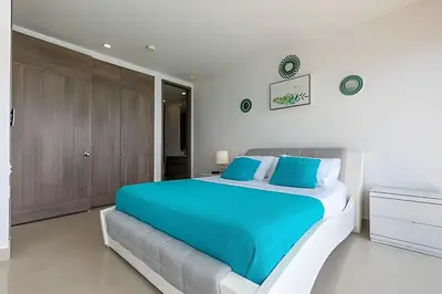 a bedroom with a large bed with blue sheets at Vista al Mar y Centro Histórico “Morros City” 26fl in Cartagena de Indias