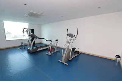 a gym with two treadmills and two exercise bikes at Exclusive Loft Bluegardens Hilton Inn Apartments Barranquilla in Barranquilla