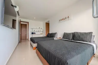 a bedroom with two beds and a couch at Piso 24 vista al mar 2BR in Cartagena de Indias
