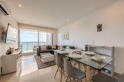 a kitchen and living room with a table and chairs at Piso 24 vista al mar 2BR in Cartagena de Indias