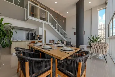 a dining room and kitchen with a wooden table and chairs at Modern 3BR duplex Apt. Great view and location in Cartagena de Indias