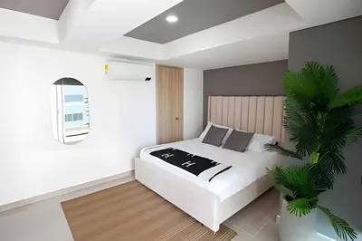 a bedroom with a white bed and a plant at Modern 3BR duplex Apt. Great view and location in Cartagena de Indias