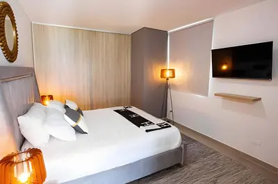 a hotel room with a bed and a flat screen tv at Modern 3BR duplex Apt. Great view and location in Cartagena de Indias