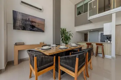a dining room with a wooden table and chairs at Modern 3BR duplex Apt. Great view and location in Cartagena de Indias