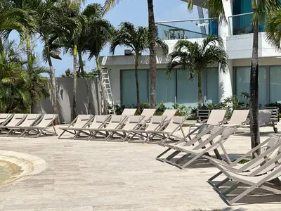 a row of lounge chairs in front of a building at Apartamento con Salida al Mar en Condominio Turístico y Hotel Sonnesta Cartagena, in Cartagena de Indias