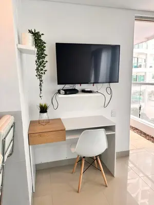 a desk with a monitor and a chair in a room at Apartamento con Salida al Mar en Condominio Turístico y Hotel Sonnesta Cartagena, in Cartagena de Indias