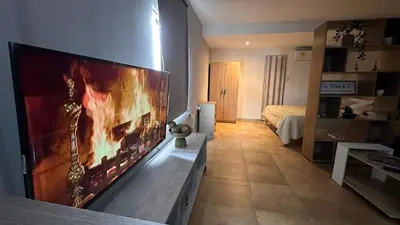 a room with a large flat screen tv on a wall at A 5 mins de CC único King, Aire, Wi-Fi, Cocina in La Mina