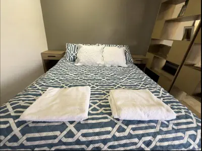 a bed with two towels on it in a room at A 5 mins de CC único King, Aire, Wi-Fi, Cocina in La Mina