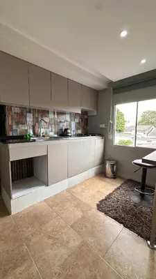 a kitchen with white cabinets and a table and a window at A 5 mins de CC único King, Aire, Wi-Fi, Cocina in La Mina
