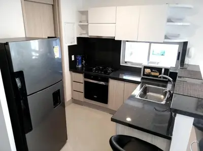 a kitchen with a refrigerator and a black counter top at Luxury Apartment - Stunning Sea View in Cartagena de Indias