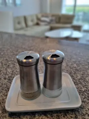 two salt and pepper shakers sitting on a white plate at Apto en Morros Epic Cartagena in Cartagena de Indias