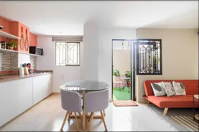 a kitchen and living room with a table and a couch at Lindo apto cerca del Malecón con patio y terraza in Barranquilla