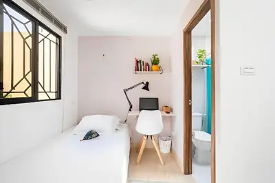 a bedroom with two beds and a desk with a computer at Lindo apto cerca del Malecón con patio y terraza in Barranquilla