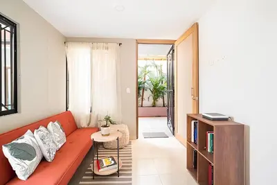 a living room with a red couch and a table at Lindo apto cerca del Malecón con patio y terraza in Barranquilla