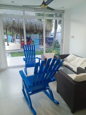 two blue chairs and a table in a living room at Condominio de Cabañas Cangrejo Azul in El Bobo