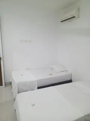 two beds in a room with white walls at Condominio de Cabañas Cangrejo Azul in El Bobo
