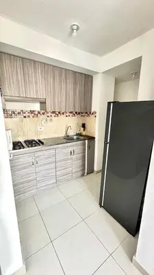 a kitchen with a black refrigerator in a room at Apartamento amoblado cerca al mar in Cartagena de Indias