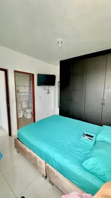 a bedroom with a large bed with a blue blanket at Apartamento amoblado cerca al mar in Cartagena de Indias