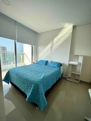 a bedroom with a blue bed and a large window at CasaMaha Cartagena Espectacular Apartamento in Cartagena de Indias