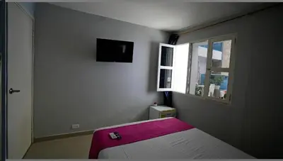 a bedroom with a bed with a pink blanket on it at Hotel Casa Bellamare in Cartagena de Indias