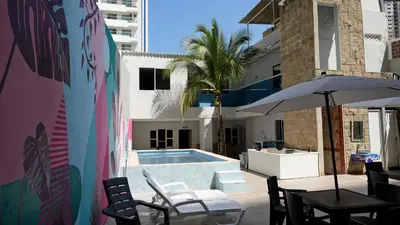 a pool with a table and chairs and an umbrella at Hotel Casa Bellamare in Cartagena de Indias