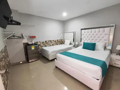 a hotel room with two beds and a television at Hotel Casa Bellamare in Cartagena de Indias