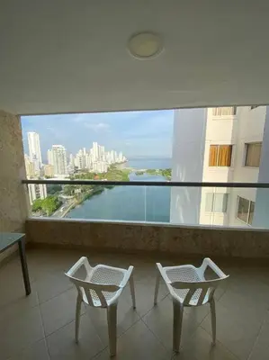 a balcony with two chairs and a view of a city at Cómodo y acogedor departamento in Cartagena de Indias