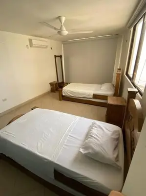 a bedroom with two beds and a window at Cómodo y acogedor departamento in Cartagena de Indias