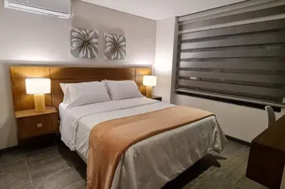a bedroom with a bed and two lamps and a window at Fantástico apartamento entero en el norte de la ciudad in Barranquilla