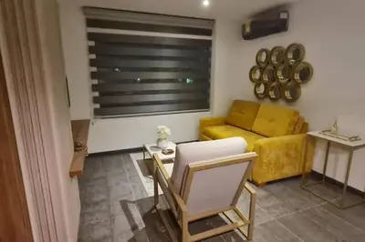 a living room with a yellow couch and a table at Fantástico apartamento entero en el norte de la ciudad in Barranquilla