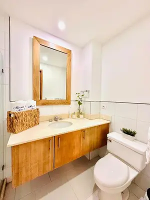 a bathroom with a toilet and a sink and a mirror at exclusivo edificio con piscina en primera linea de playa in Cartagena de Indias