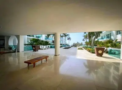 a bench in the middle of a room with a building at exclusivo edificio con piscina en primera linea de playa in Cartagena de Indias
